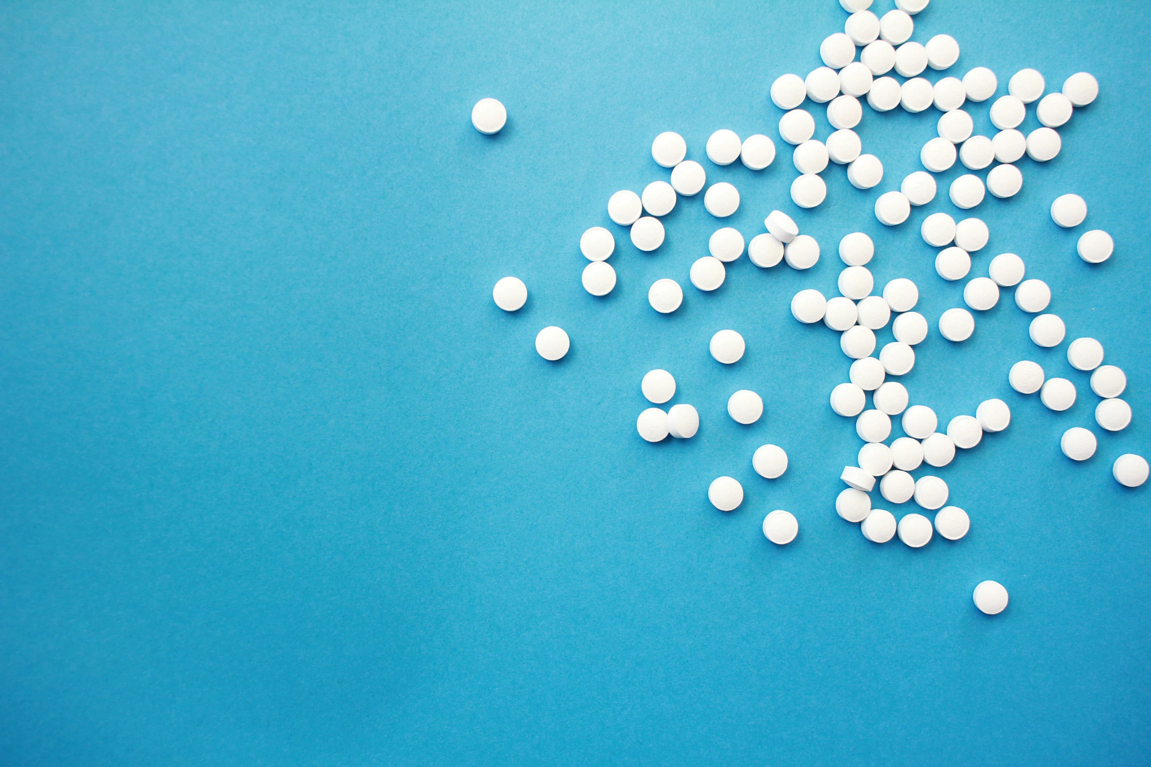 White tablets scattered on a blue background